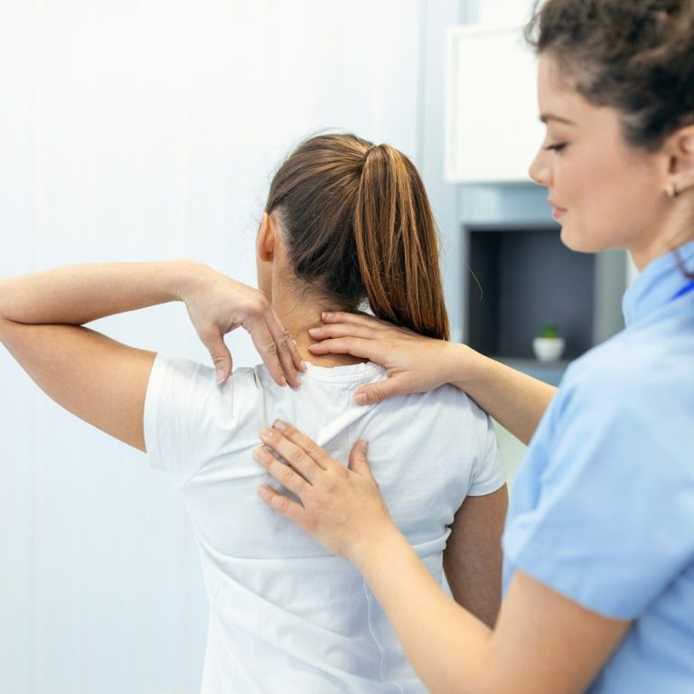 Hände auf dem Rücken eins Patienten die fühlen, wo der Schmerz sitzt
